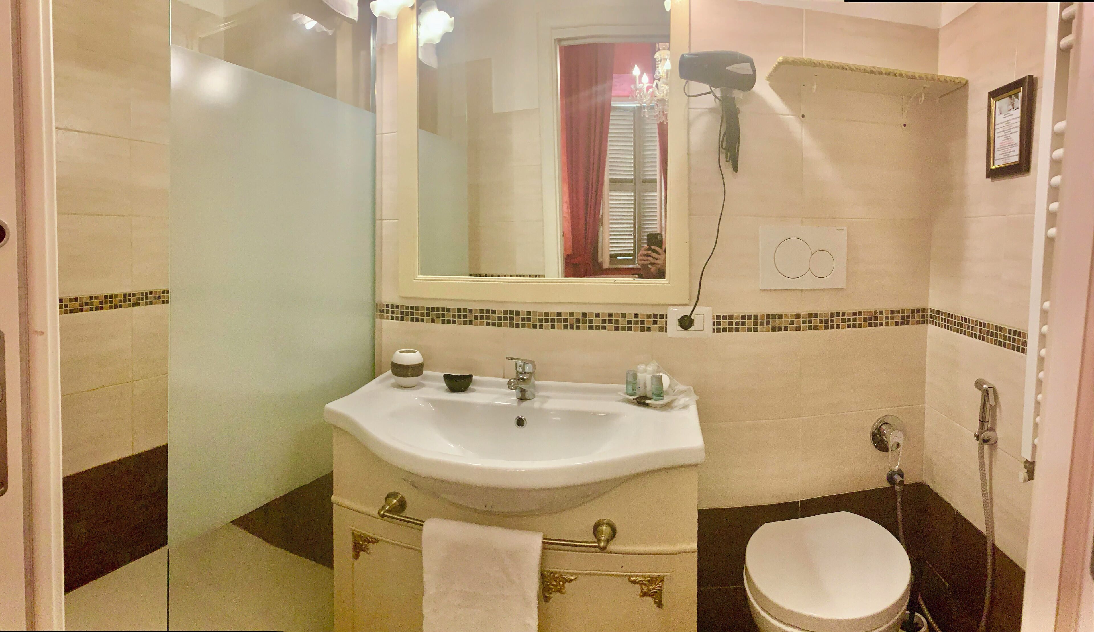 A bathroom with a sink, mirror, and toilet.