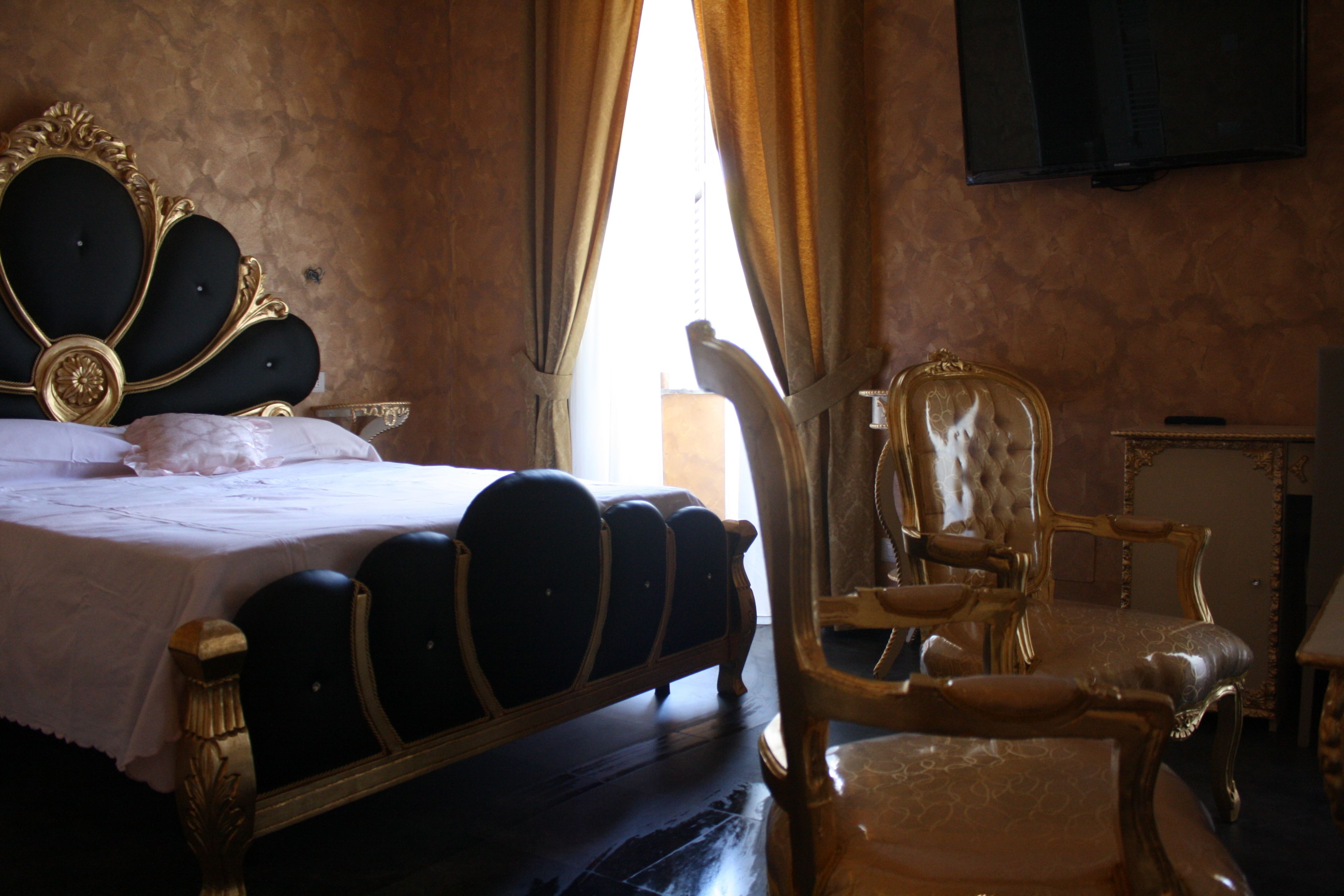 A room with a bed, a chair, and a television.