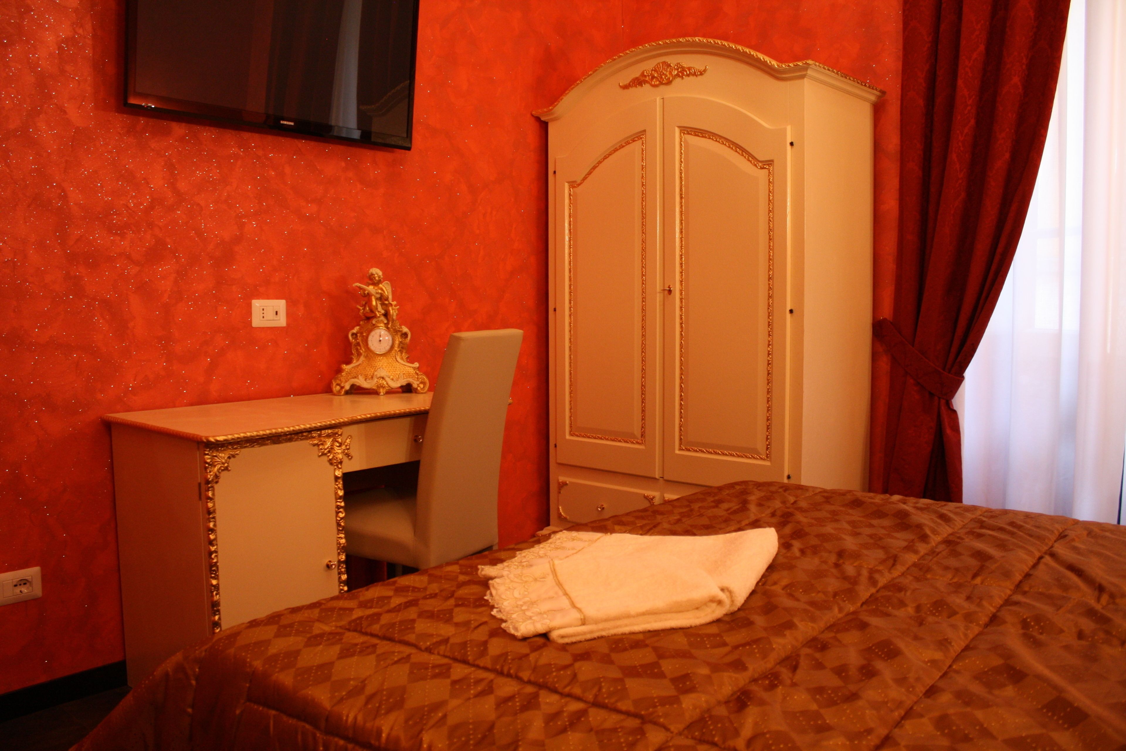 Una habitación de hotel con una cama, un escritorio y un armario.