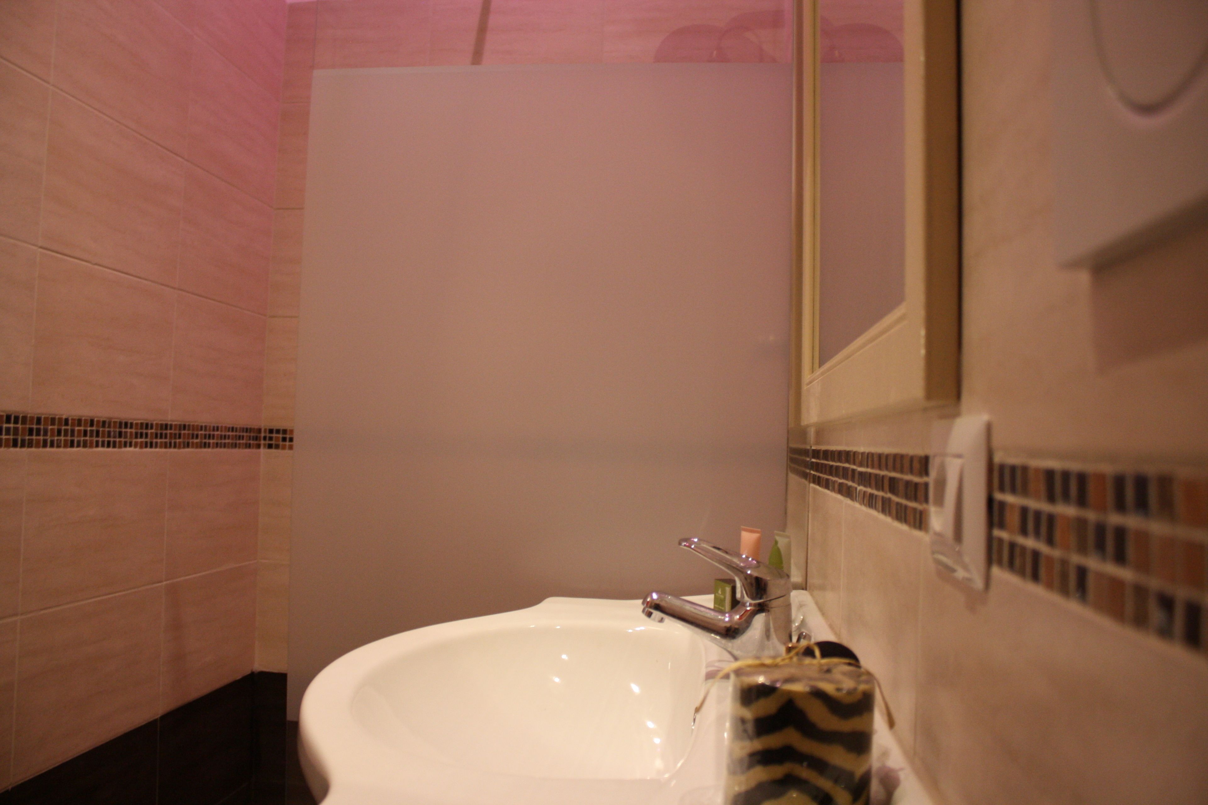 A bathroom with a white sink, a mirror, and a towel rack.