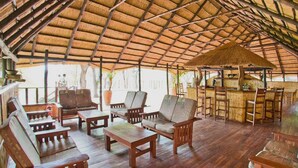 Un espacio de estar al aire libre cubierto con muebles de madera y una barra.