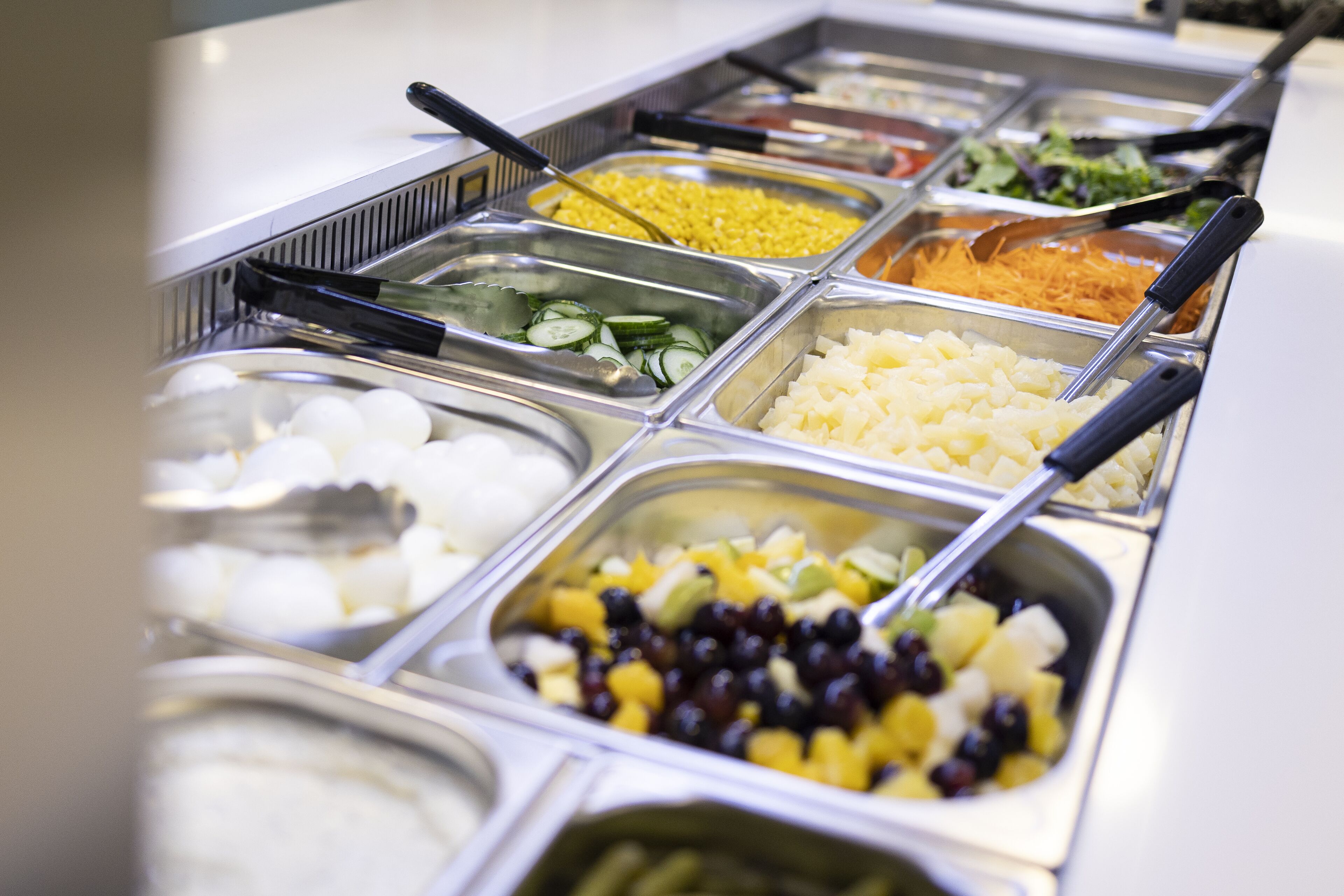 Buffet com diversos alimentos, incluindo frutas, vegetais e cereais.