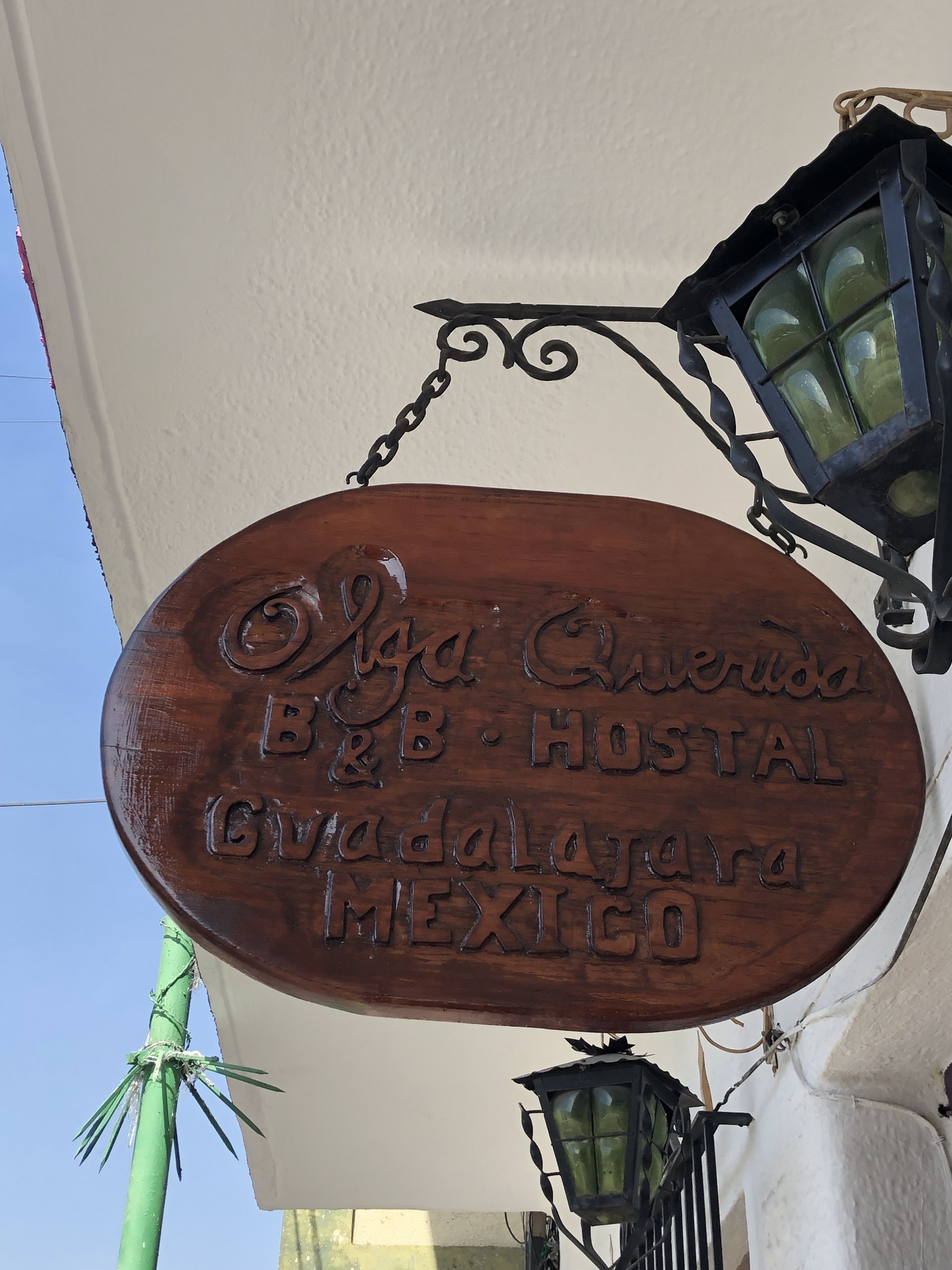 A wooden sign with embossed text indicating the name and location of a hotel.