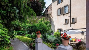 A garden with potted plants and a patio area with outdoor furniture. - Palazzo Rivola (Bergamo)