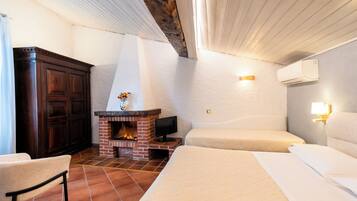 Ein Schlafzimmer mit Kamin, einem Bett, einem Fernseher und einem Kleiderschrank.