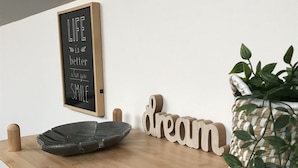 A wooden table with a chalkboard sign, wooden letter blocks spelling "dream," and a woven basket with green leaves.