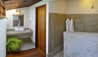 Ein Badezimmer mit Waschbecken, Spiegel, Handtuchhalter und einer großen Badewanne.