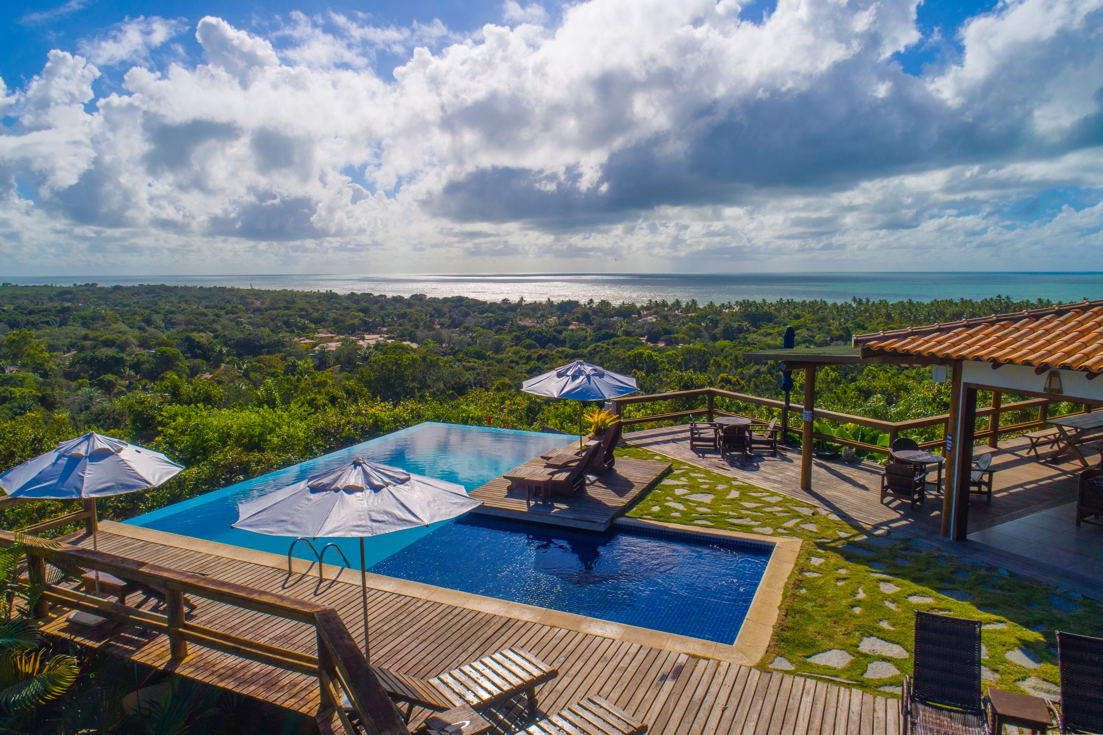 A pool area with two pools, umbrellas, and lounge chairs.