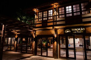 The exterior of Hotel Tororão with a wooden facade, large windows, and a signboard. - Pousada Tororão (Porto Seguro)