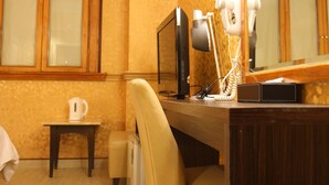 A hotel room with a wooden desk, a chair, a mirror, and a hairdryer. - Goodness Hotel (Kaohsiung)