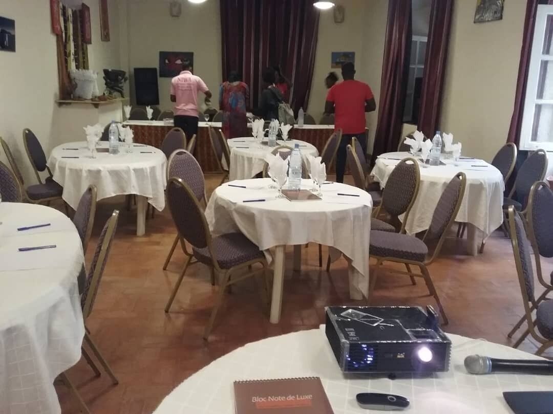 A conference room with round tables, chairs, and a podium.
