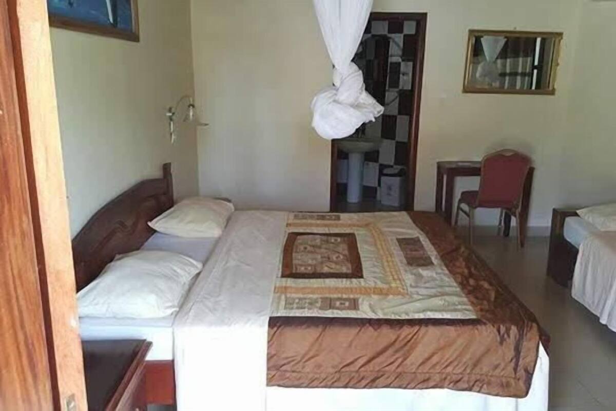 A room with a bed, a desk, and a chair.