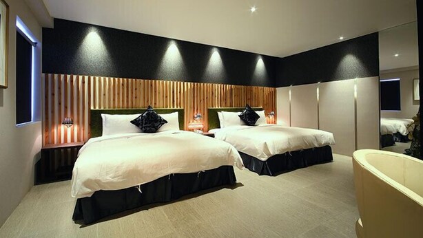 A modern hotel room with two beds, a large bathtub, and a wooden accent wall. - Leesing Hotel (Kaohsiung)