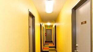 A hotel hallway with a checkered carpet, doors on either side, and a sign indicating room number 206. - Moderne Hostel (Mammoth Lakes)