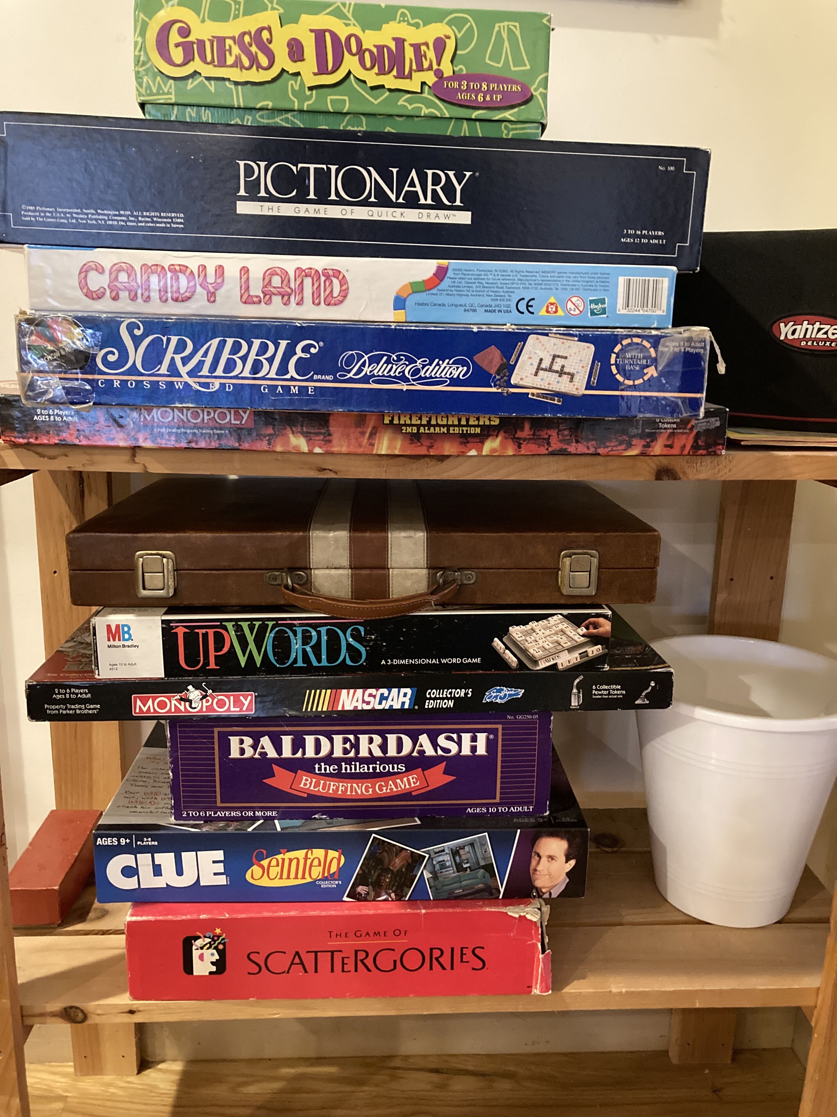 A collection of board games stacked on a shelf.