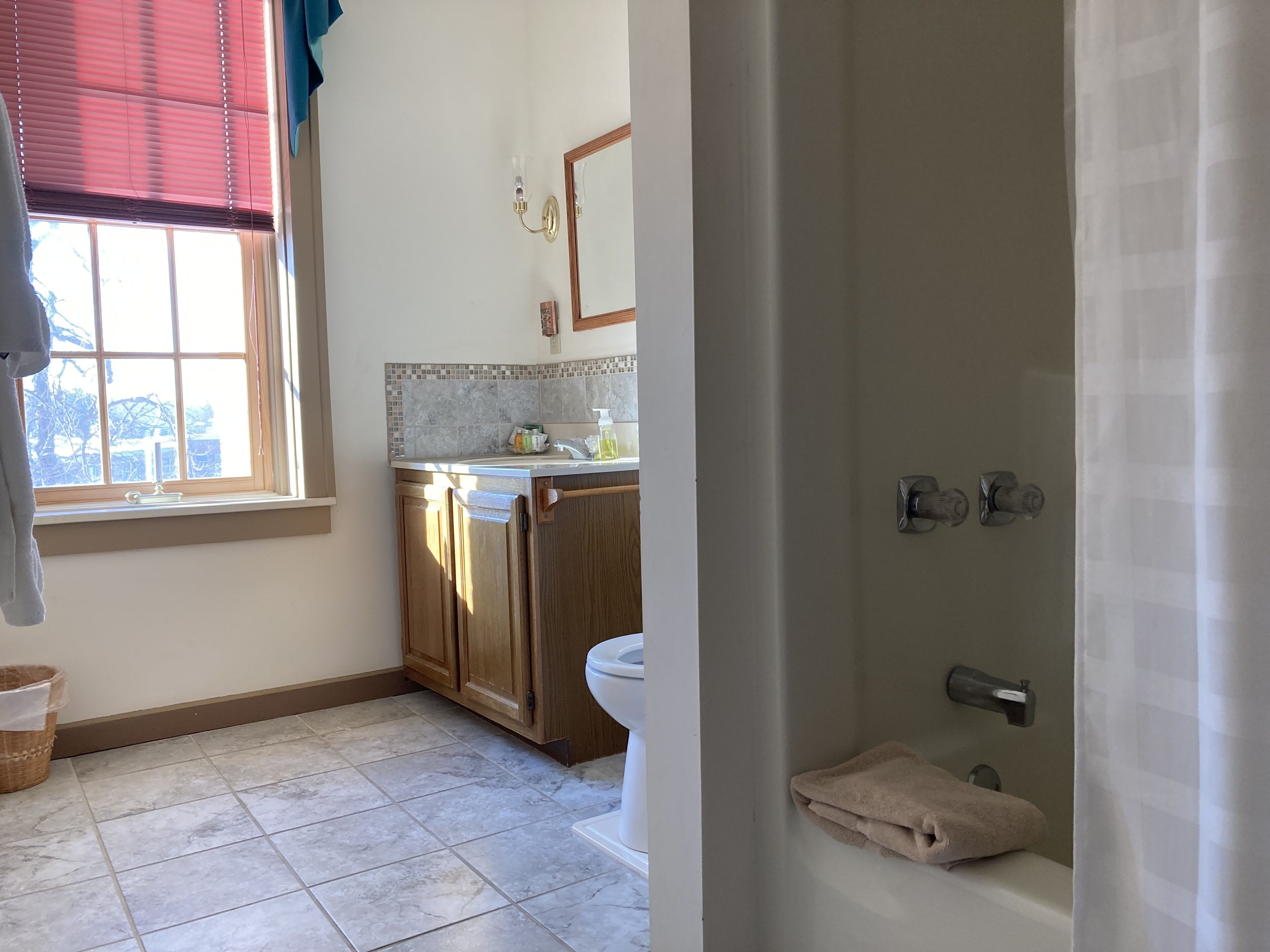 A bathroom with a toilet, sink, and shower area.