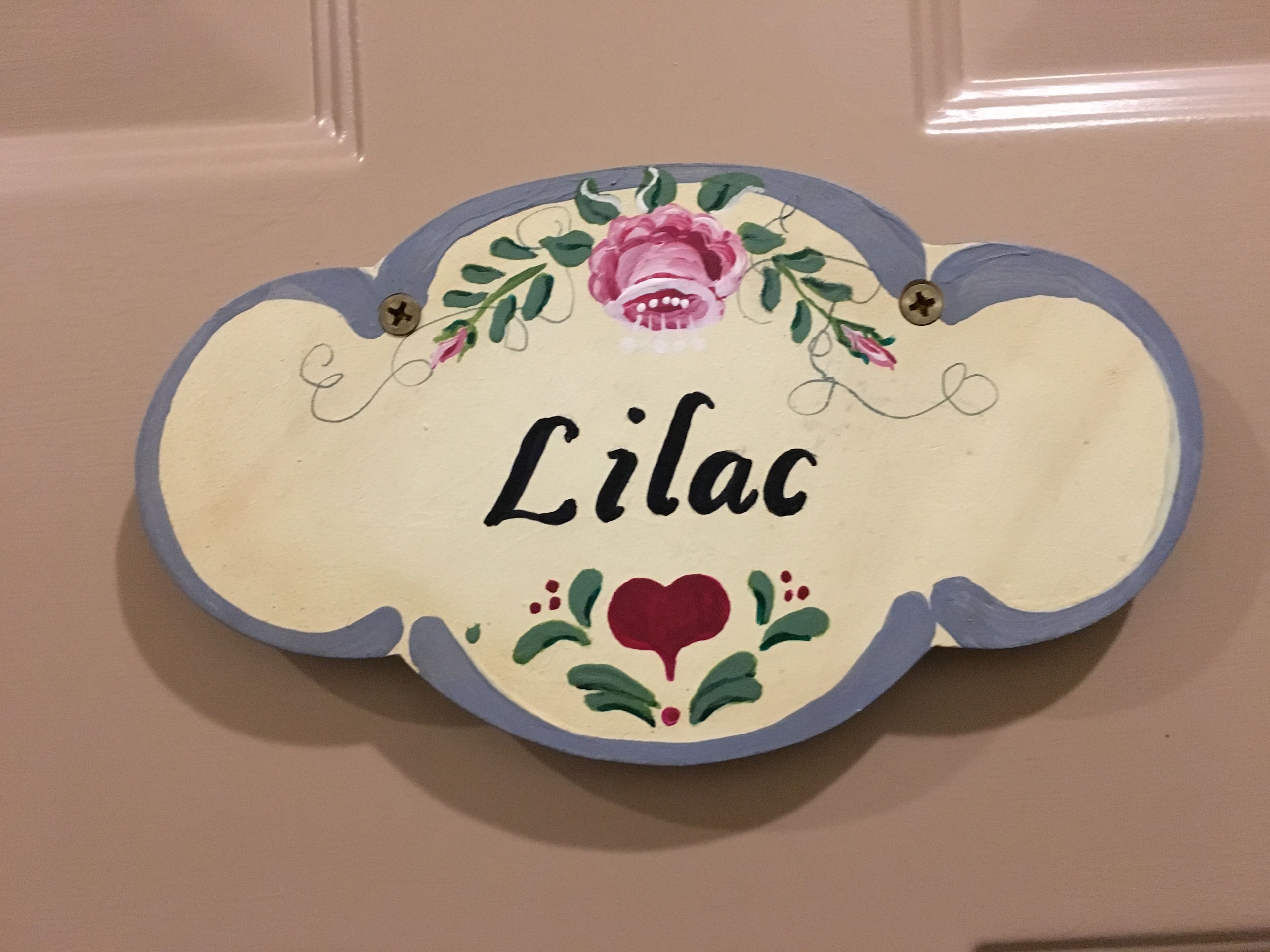 A decorative nameplate with the name "Lilac" and floral designs.