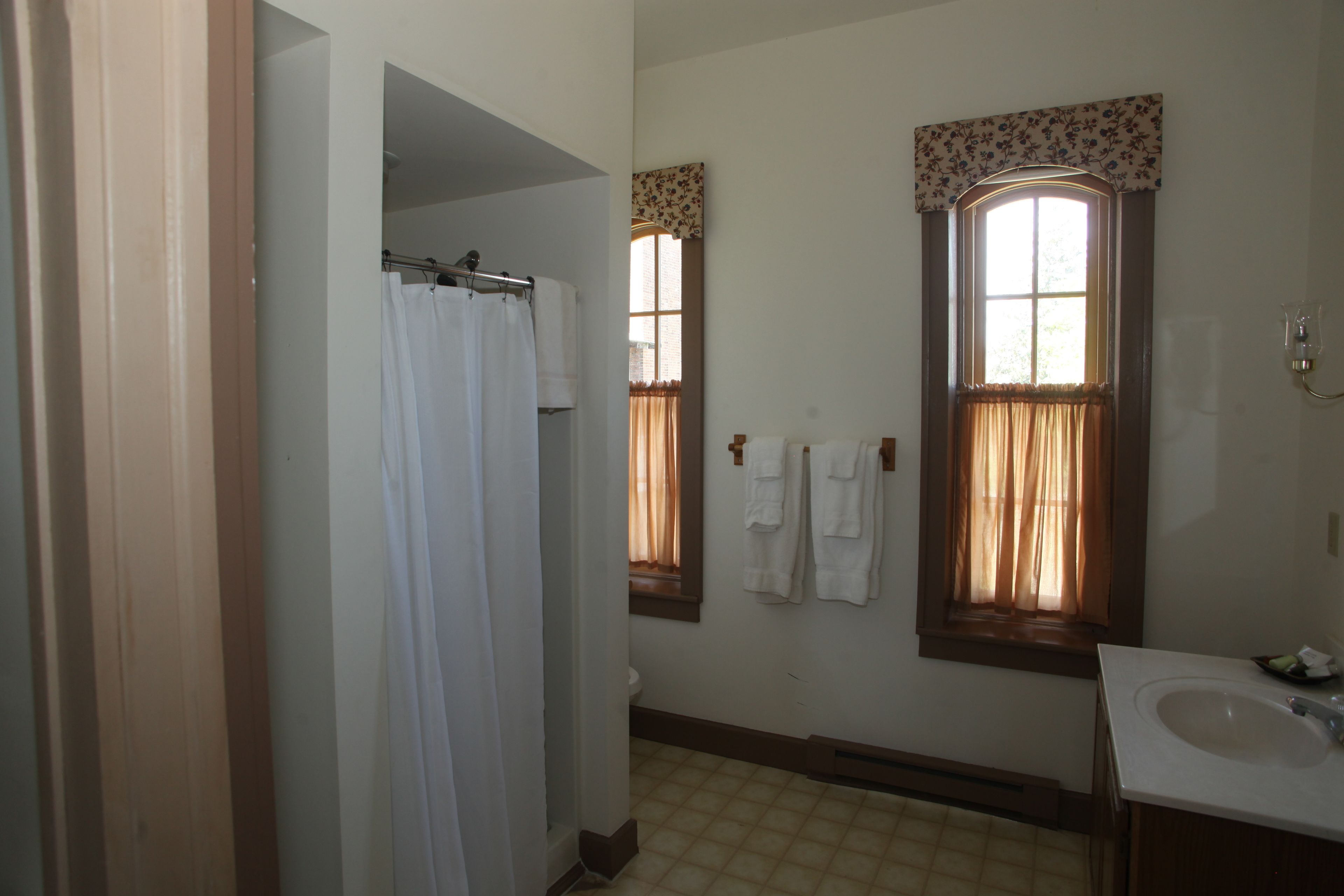 A bathroom with a toilet, a sink, and a shower area.