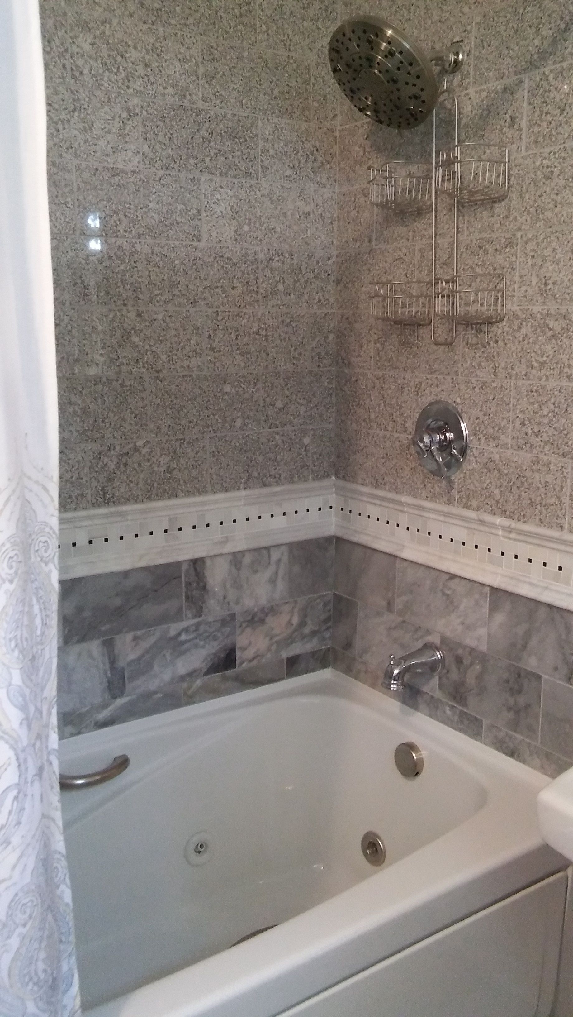 A bathroom with a bathtub, a showerhead, and a towel rack.