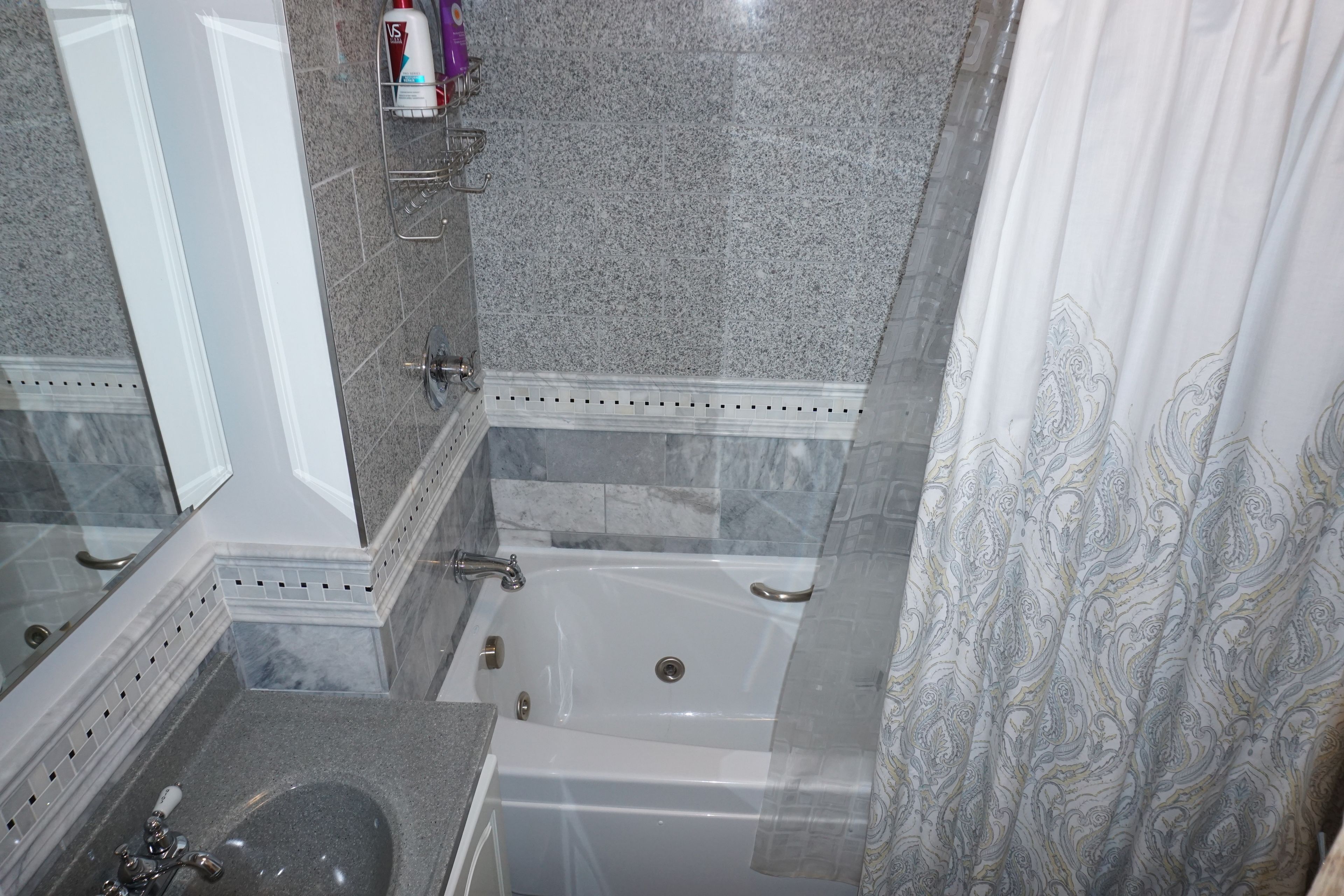 A bathroom with a bathtub, a sink, and a shower area.