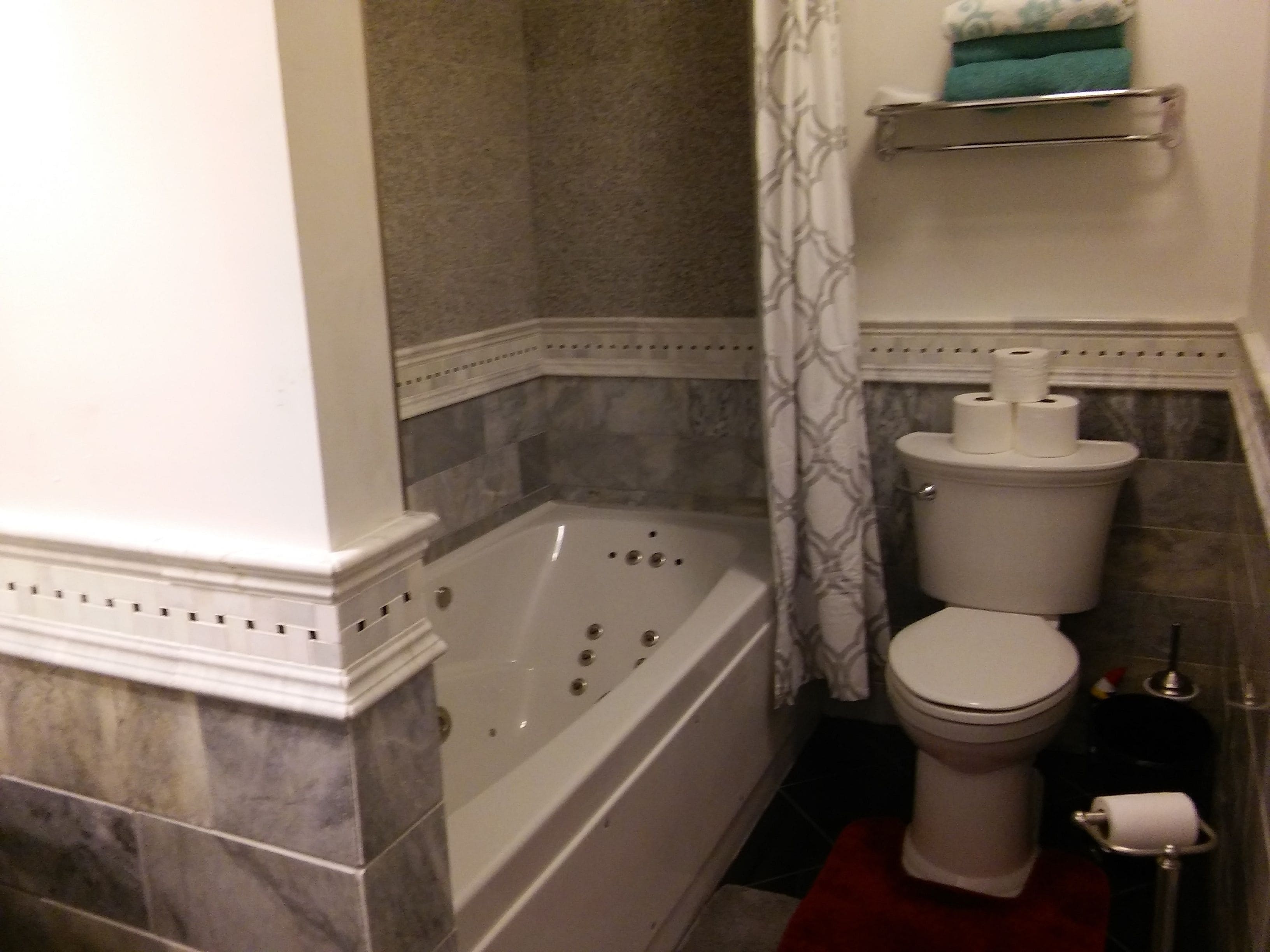 Un baño con bañera, inodoro y cortina de ducha.