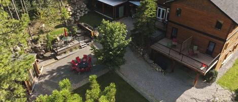 A lodge with a patio area, a covered outdoor seating area, and a large wooden building with a balcony.