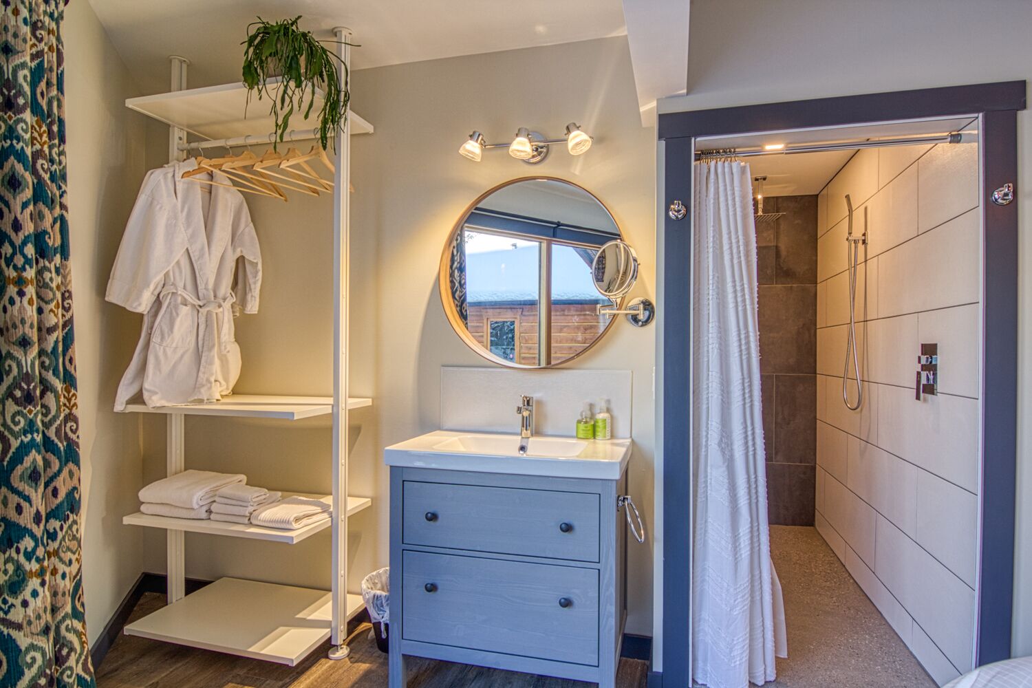A modern bathroom with a vanity, a mirror, and a shower.