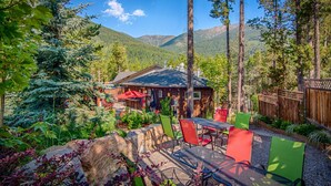 A lodge with outdoor seating and a mountain backdrop. - Earl Grey Lodge (Panorama)