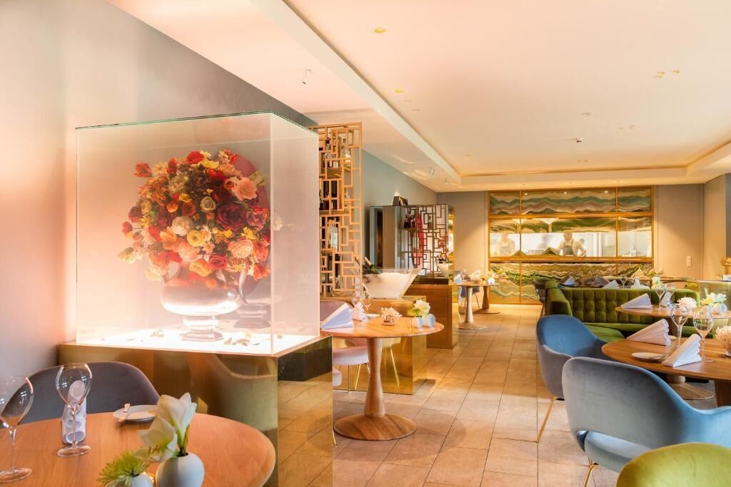 A restaurant with round tables, chairs, and a large floral centerpiece.