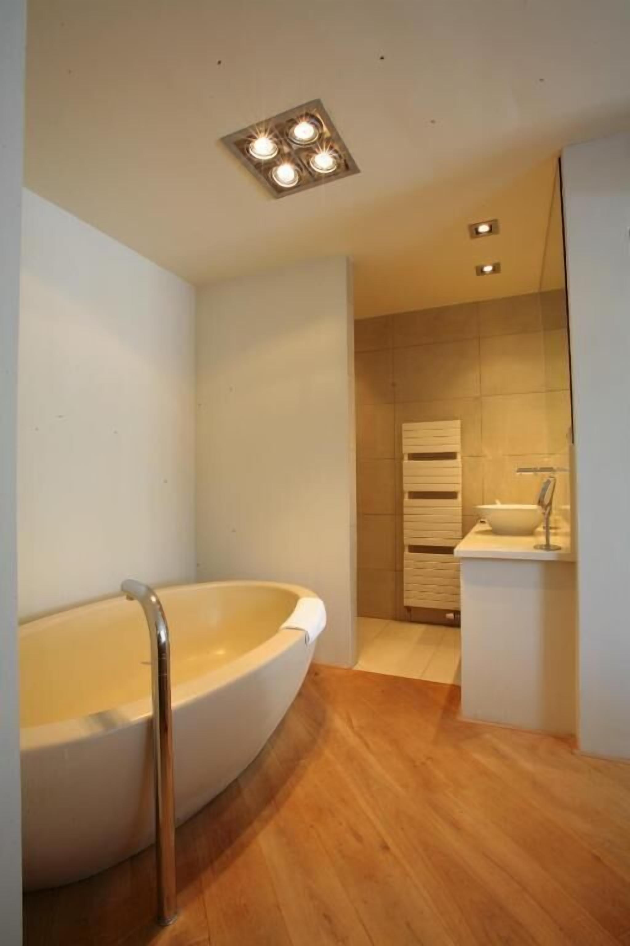 Un baño moderno con una bañera independiente, un tocador con espejo y una zona de ducha.