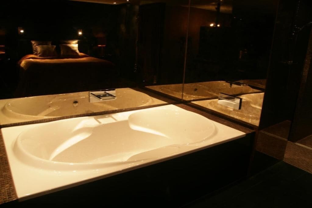 Een moderne badkamer met een groot, ovaal wastafel en een spiegel erboven.