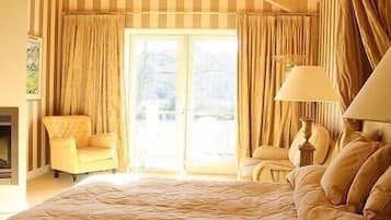 Um quarto amplo com uma cama grande, uma cadeira, um abajur e vista para o exterior através de uma porta deslizante.
