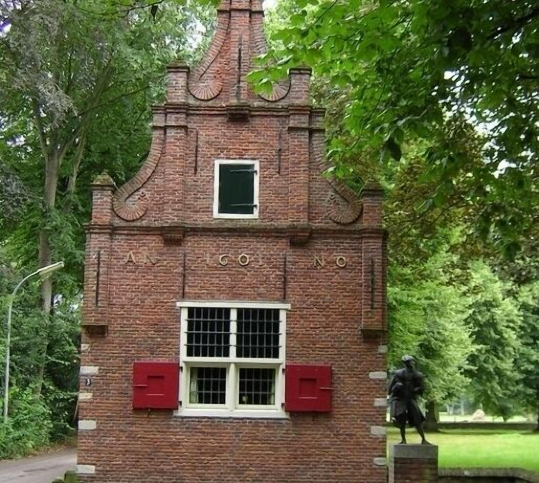 A brick building with a small window and two red mailboxes.