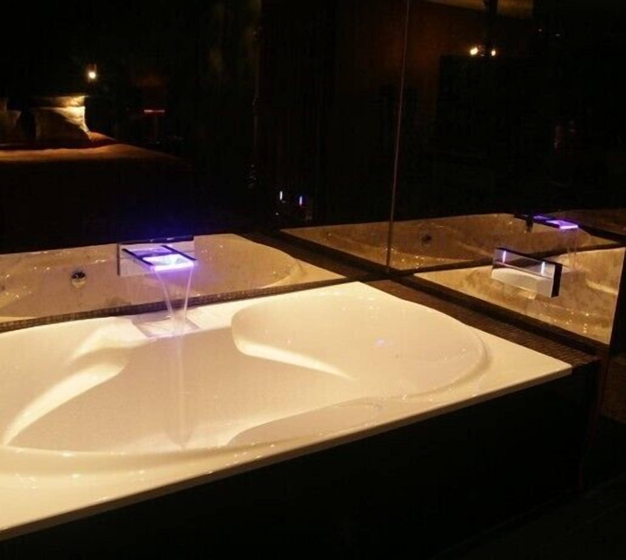 A modern bathroom with a large, white sink and a mirror above it.