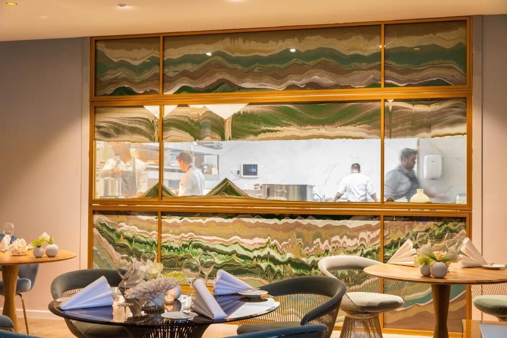 A restaurant with a modern interior, featuring a unique wall art installation and contemporary furniture.