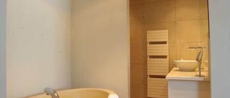 Une salle de bain moderne avec une baignoire sur pieds, un meuble-lavabo et un porte-serviettes.