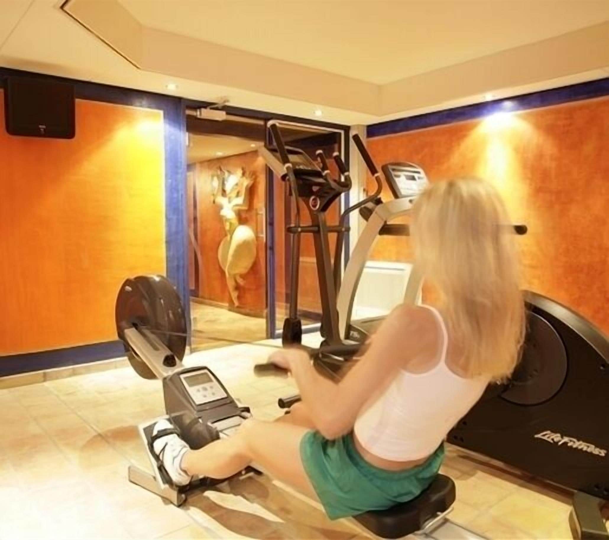 A gym with exercise equipment, a treadmill, and a stationary bike.