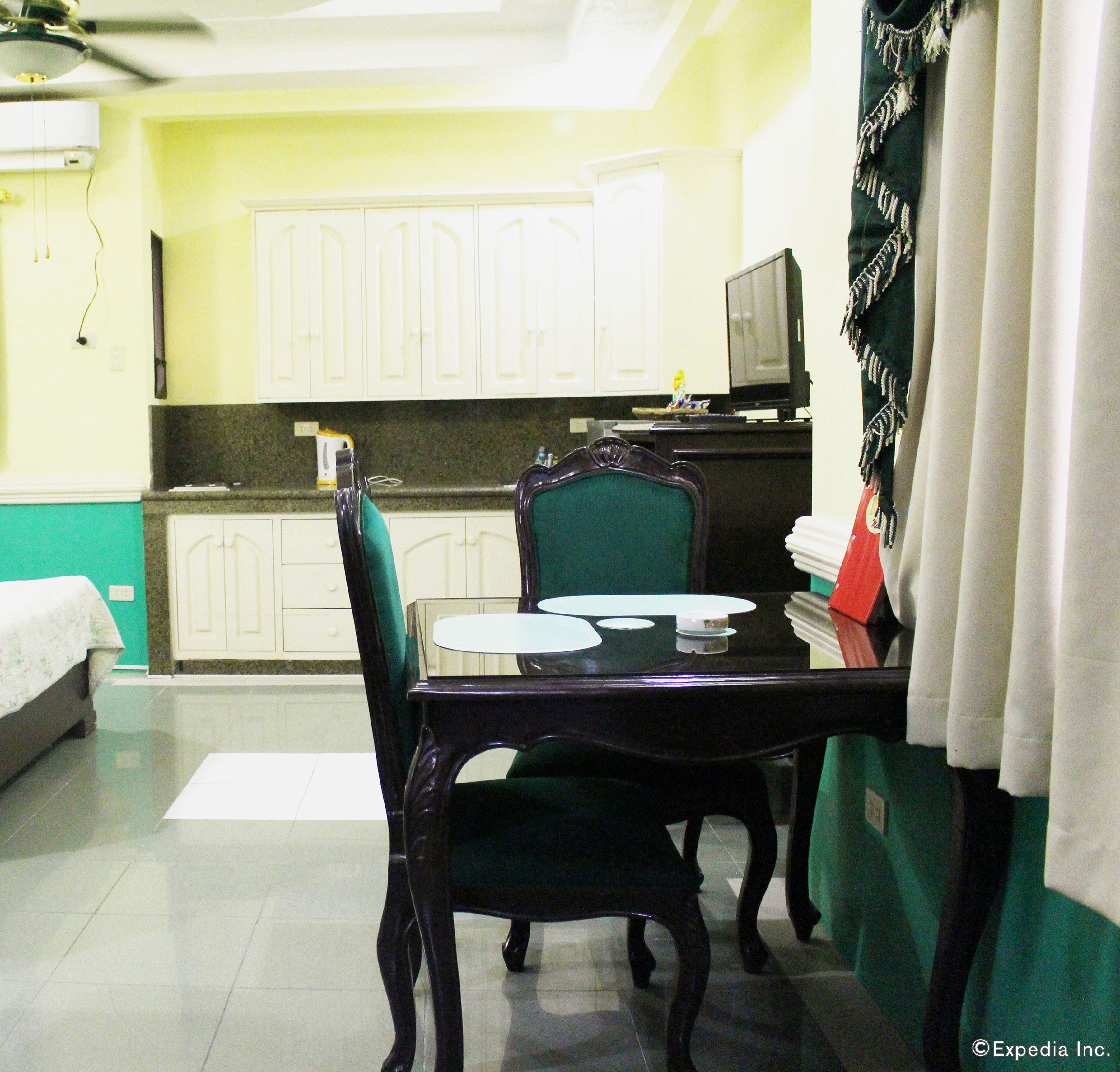 A compact hotel room with a dining area, a bed, and a television.