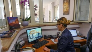 A professional office setting with a desk, computer, and a person working.