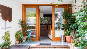 A cozy entrance with a wooden door, a small table with chairs, and potted plants. - Mare Nostrum Apart (Kas)