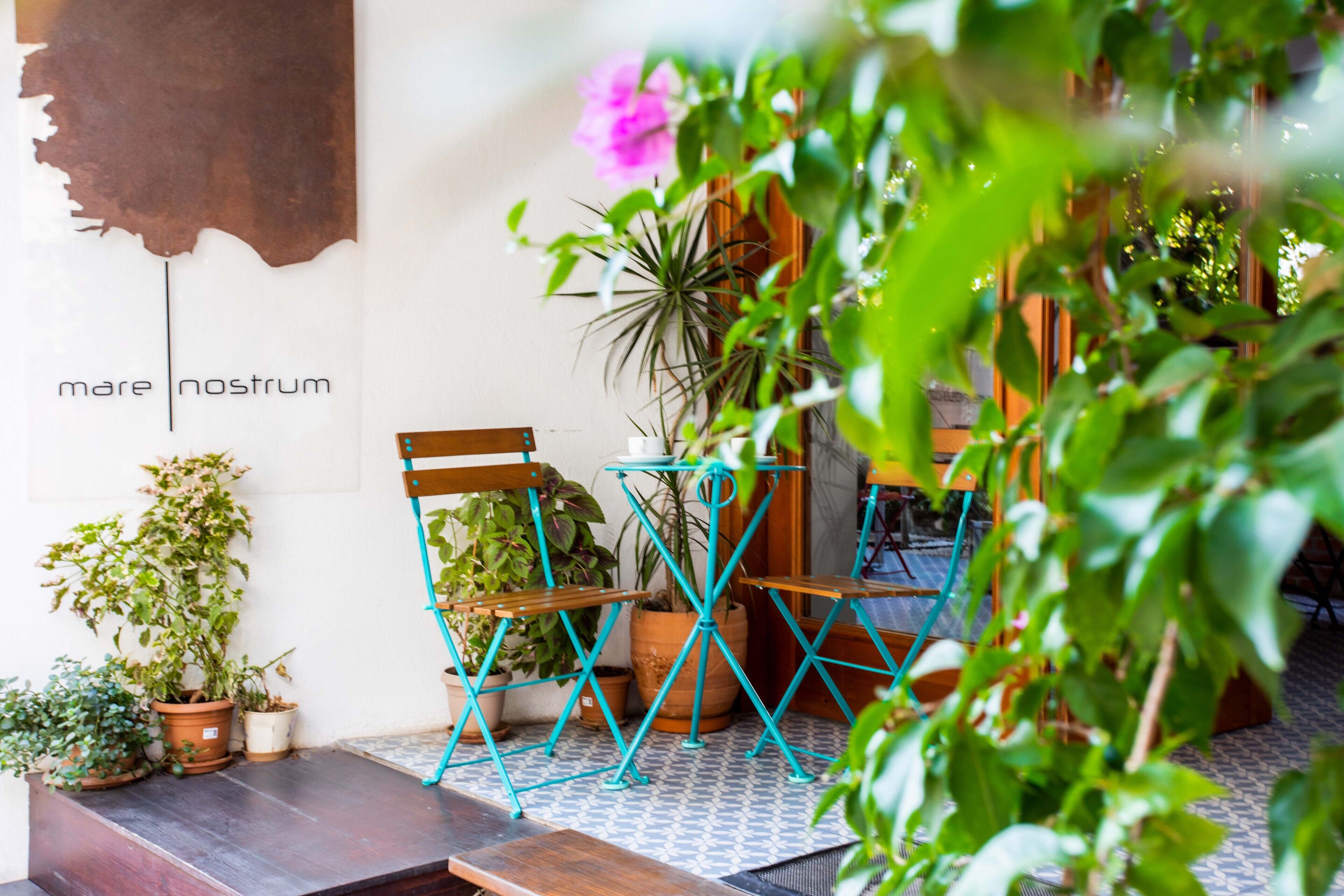A patio area with wooden chairs and potted plants.