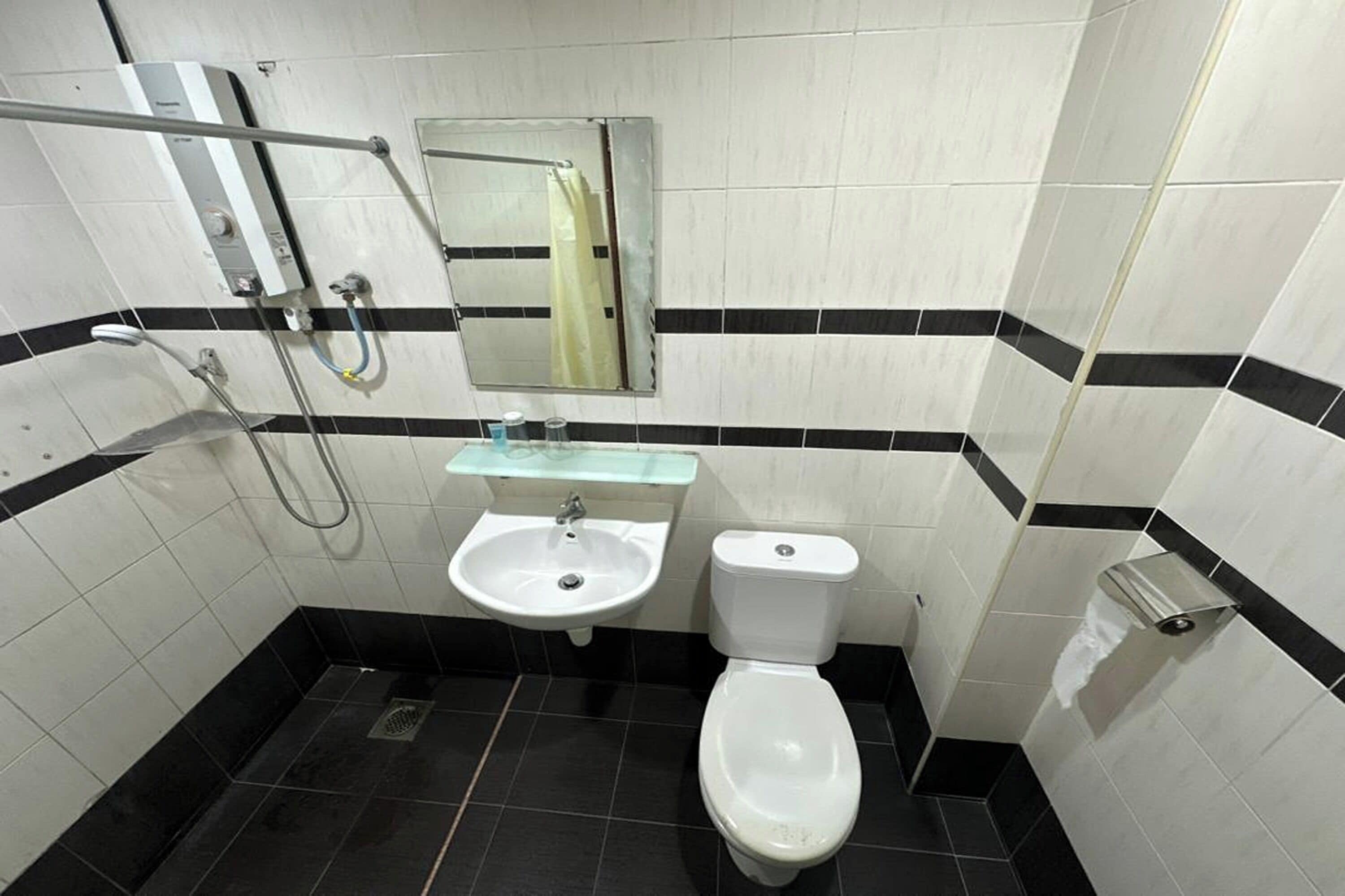 A bathroom with a white sink, a toilet, and a shower area.