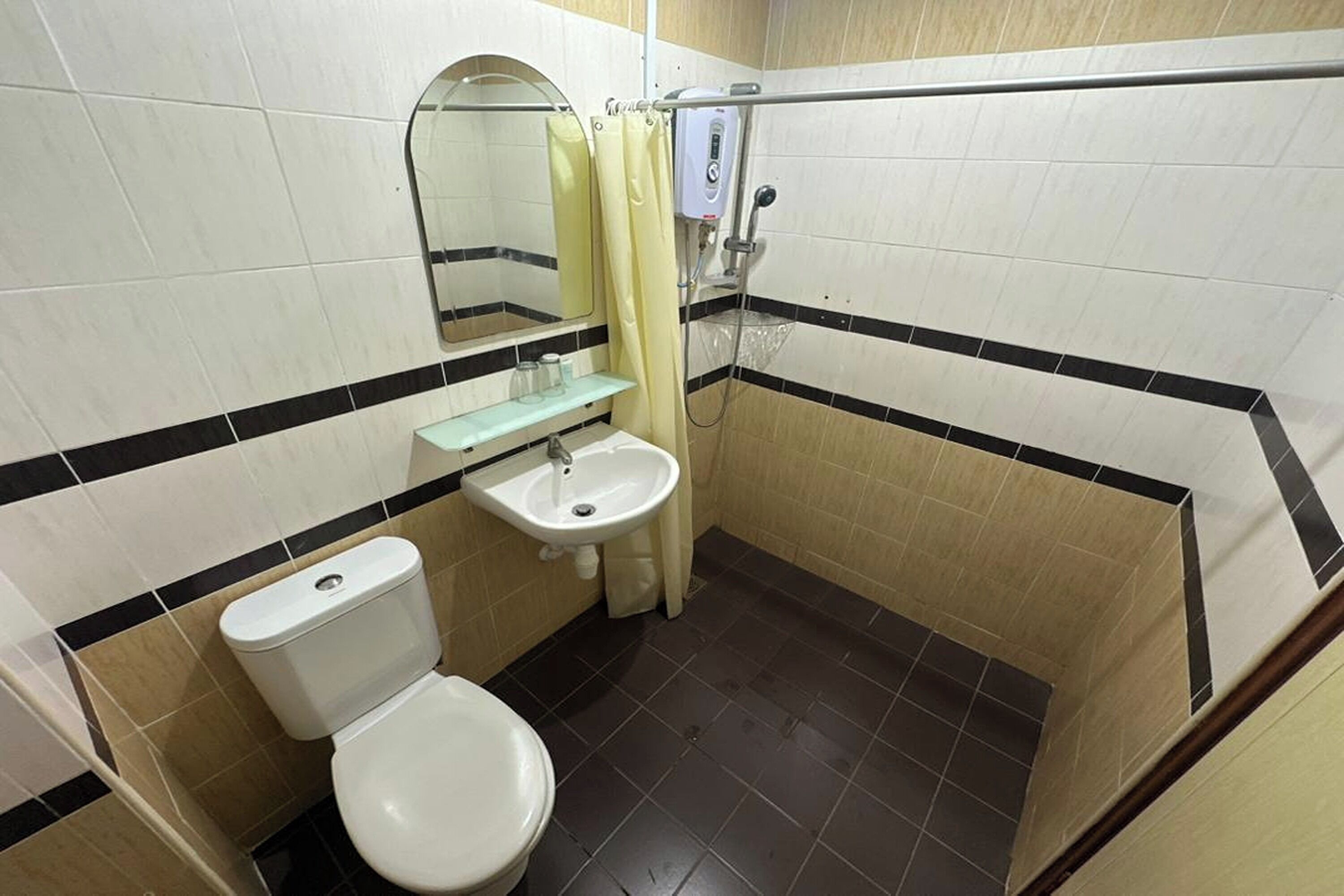 Un baño pequeño con inodoro, lavamanos y ducha.