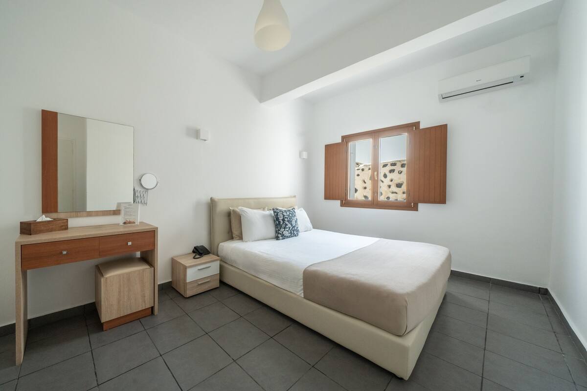 Une chambre à coucher moderne avec un lit, une table de chevet et une commode.