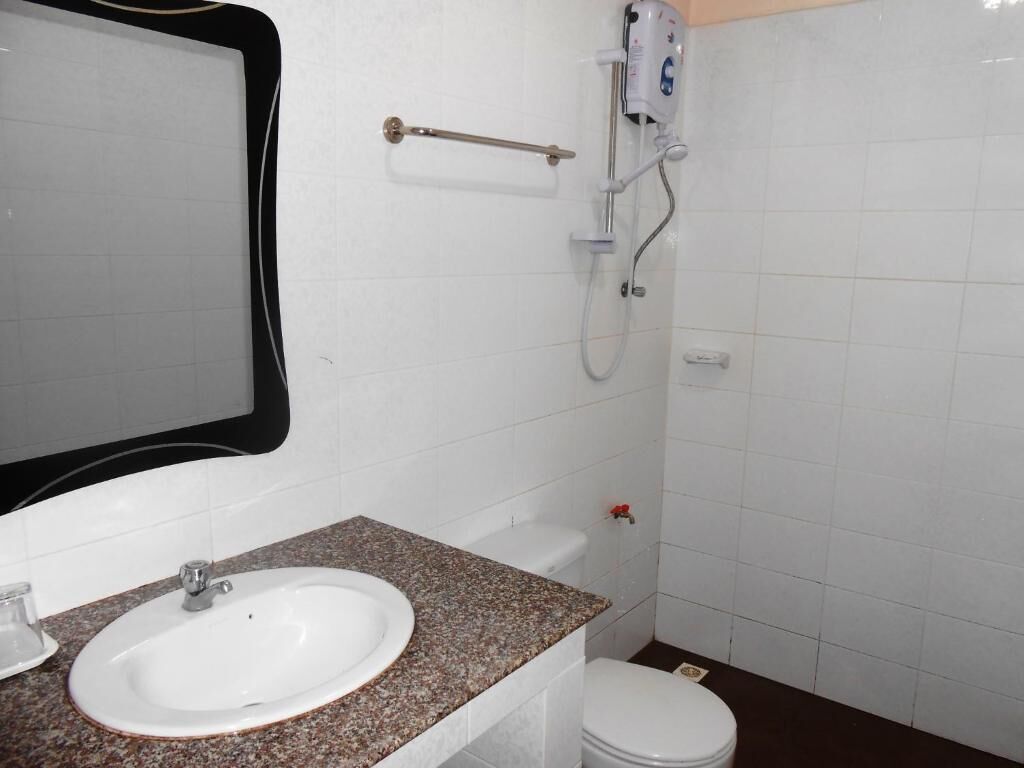 A bathroom with a white sink, a mirror, a shower, and a toilet.