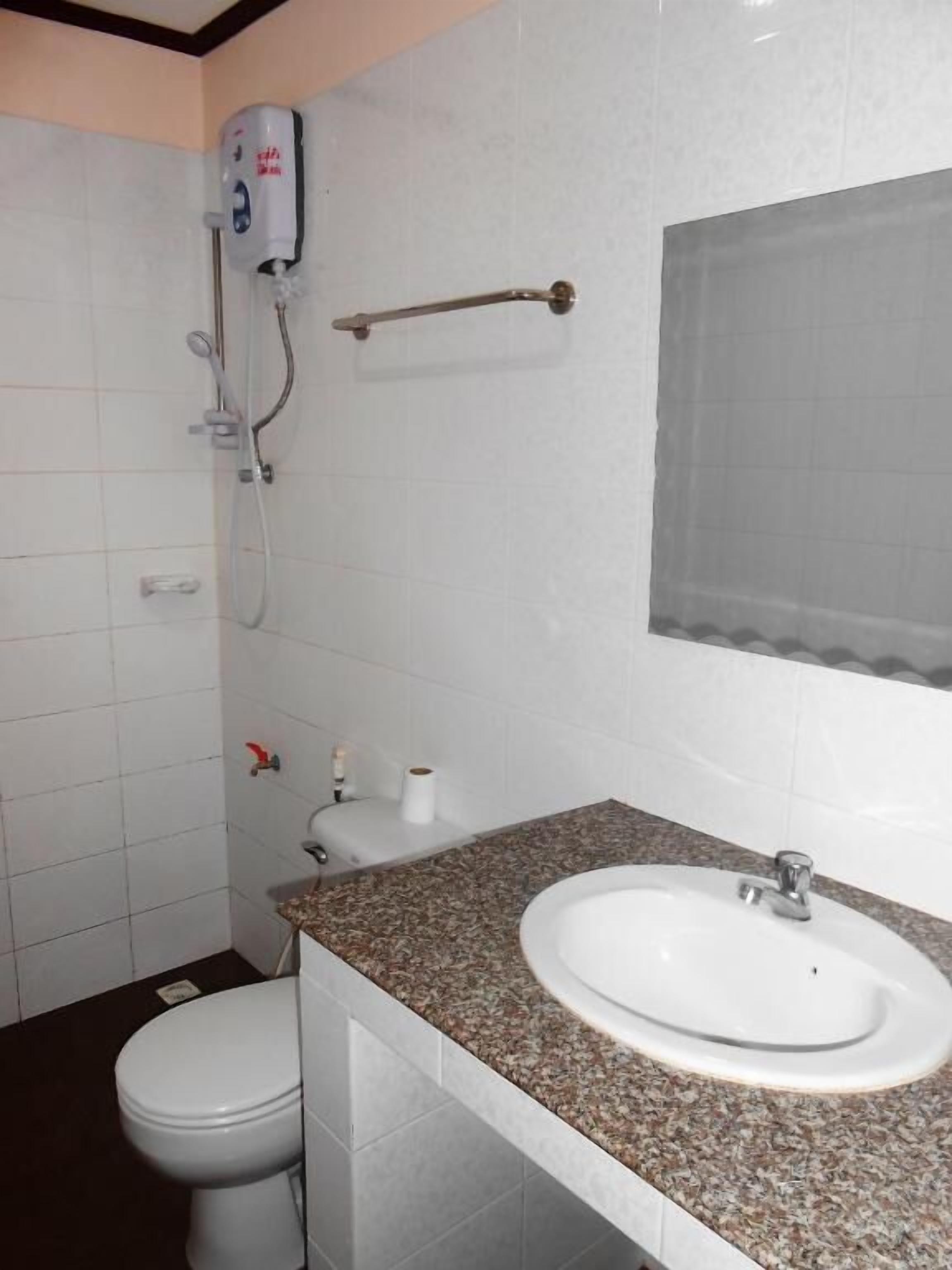 A bathroom with a white toilet, a sink with a granite countertop, a handheld showerhead, and a towel rack.
