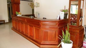 Una recepción con encimera de madera, una planta en maceta y un espejo.
