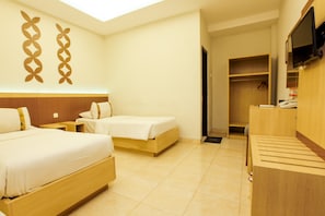 A hotel room with two beds, a TV, and a wardrobe. - Mawar Asri Hotel (Yogyakarta)