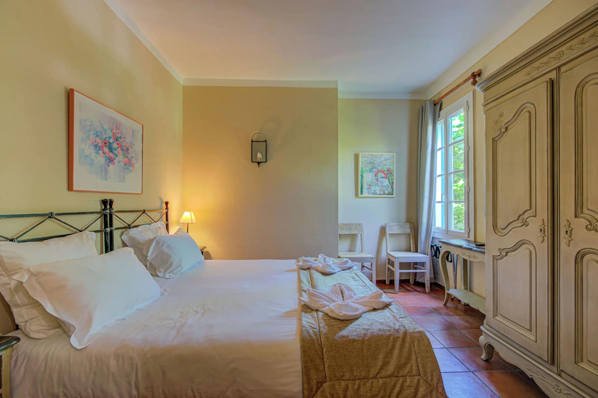 Ein Hotelzimmer mit Bett, Schreibtisch, Stuhl und Kleiderschrank.