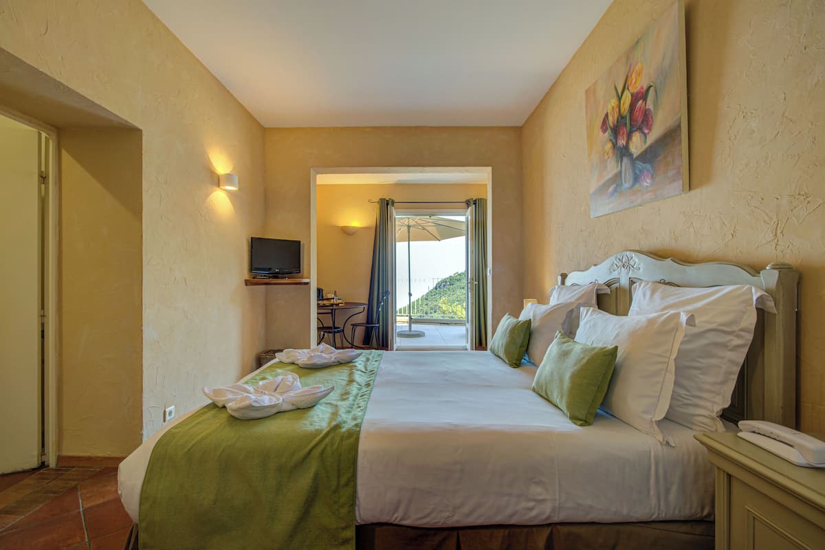 Ein Hotelzimmer mit einem Bett, einem Schreibtisch, einem Stuhl, einem Fernseher und einem Bild an der Wand.